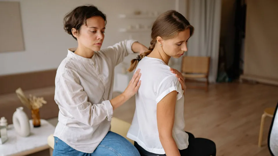 A physiotherapist working on a patient’s back in a bright clinic