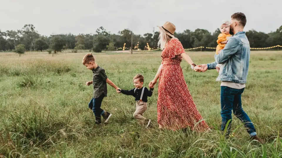 A family walking hand in hand through a field